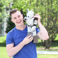 Picture of person holding small humanoid robot on their shoulder
